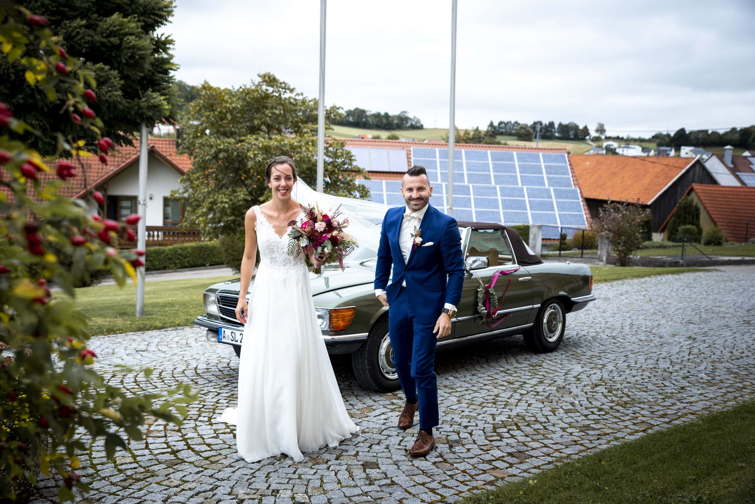 Das Brautpaar steigt aus dem Auto und läuft zur Pfarrkirche bei der Landhochzeit in Aindling.