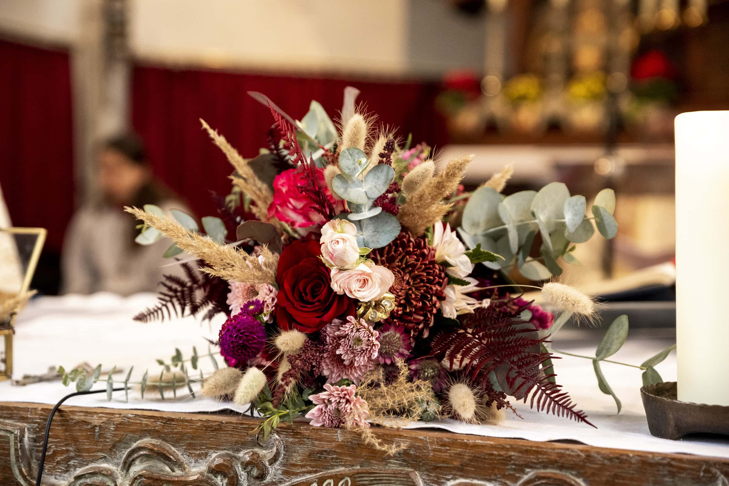 Eine Nahaufnahme vom Brautstrauß auf dem Altar.