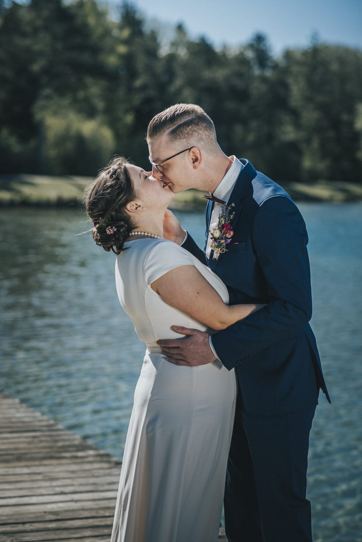 Das Brautpaar küsst sich am Weitmannsee bei Kissing.