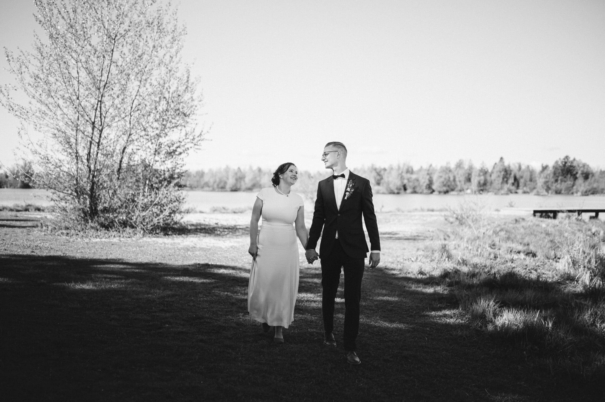 Ein Bild in schwarz-weiß. Das Brautpaar spaziert im Hochzeitsshooting in Kissing.