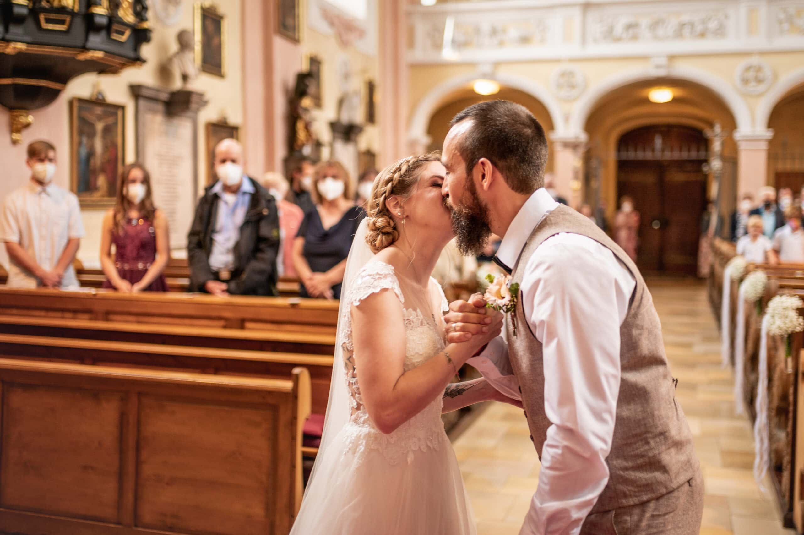 Das Brautpaar küsst sich in Kirche St. Peter und Paul in Affing.