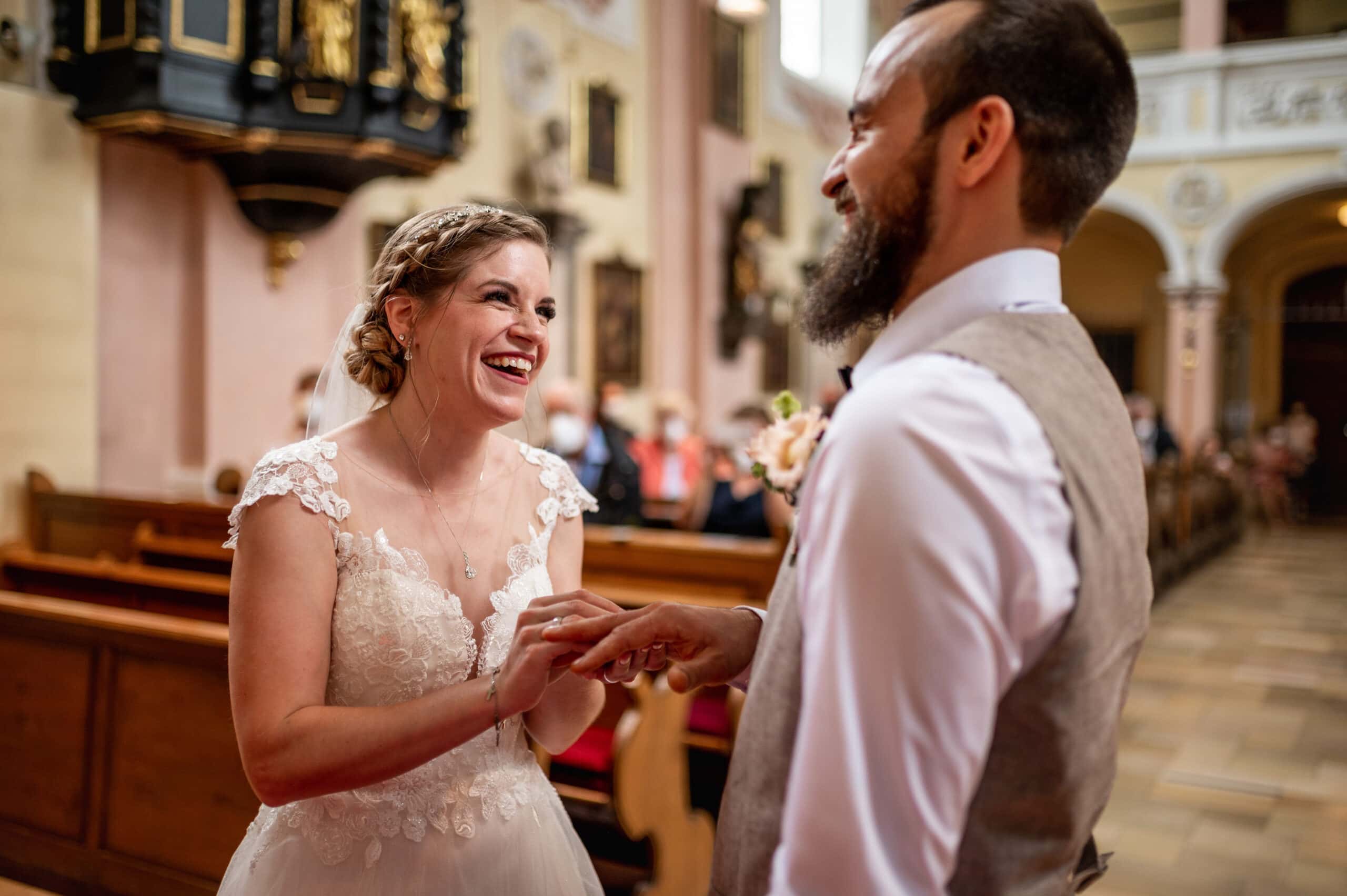 Das Brautpaar steckt sich die Ringe an bei der Hochzeit in Affing in der Kirche St. Peter und Paul in Affing.