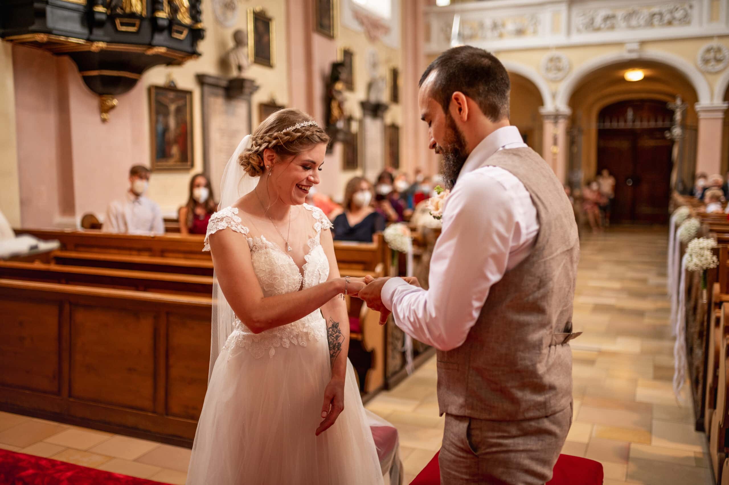 Das Brautpaar steckt sich die Ringe a bei der Hochzeit in der Kirche St. Peter und Paul in Affing.