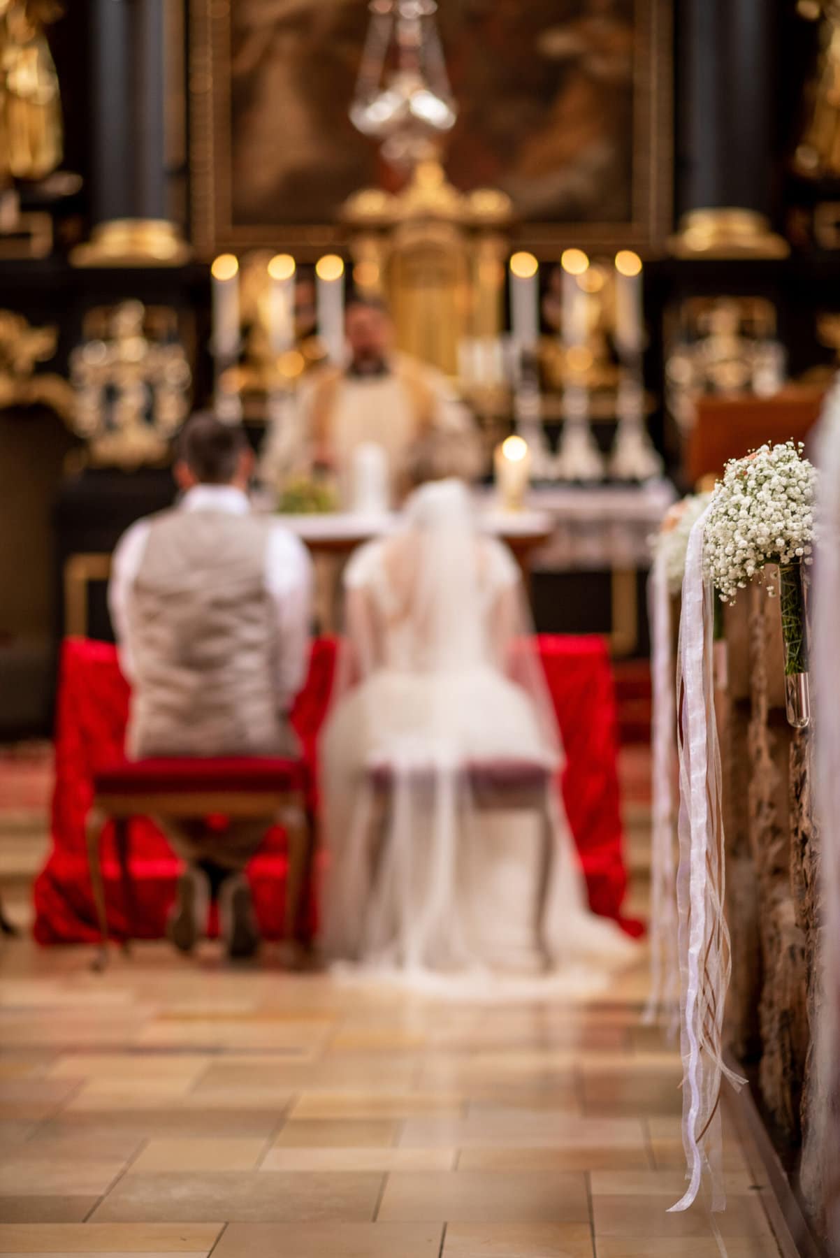 Das Brautpaar sitzt am Altar in der Kirche St. Peter und Paul in Affing.