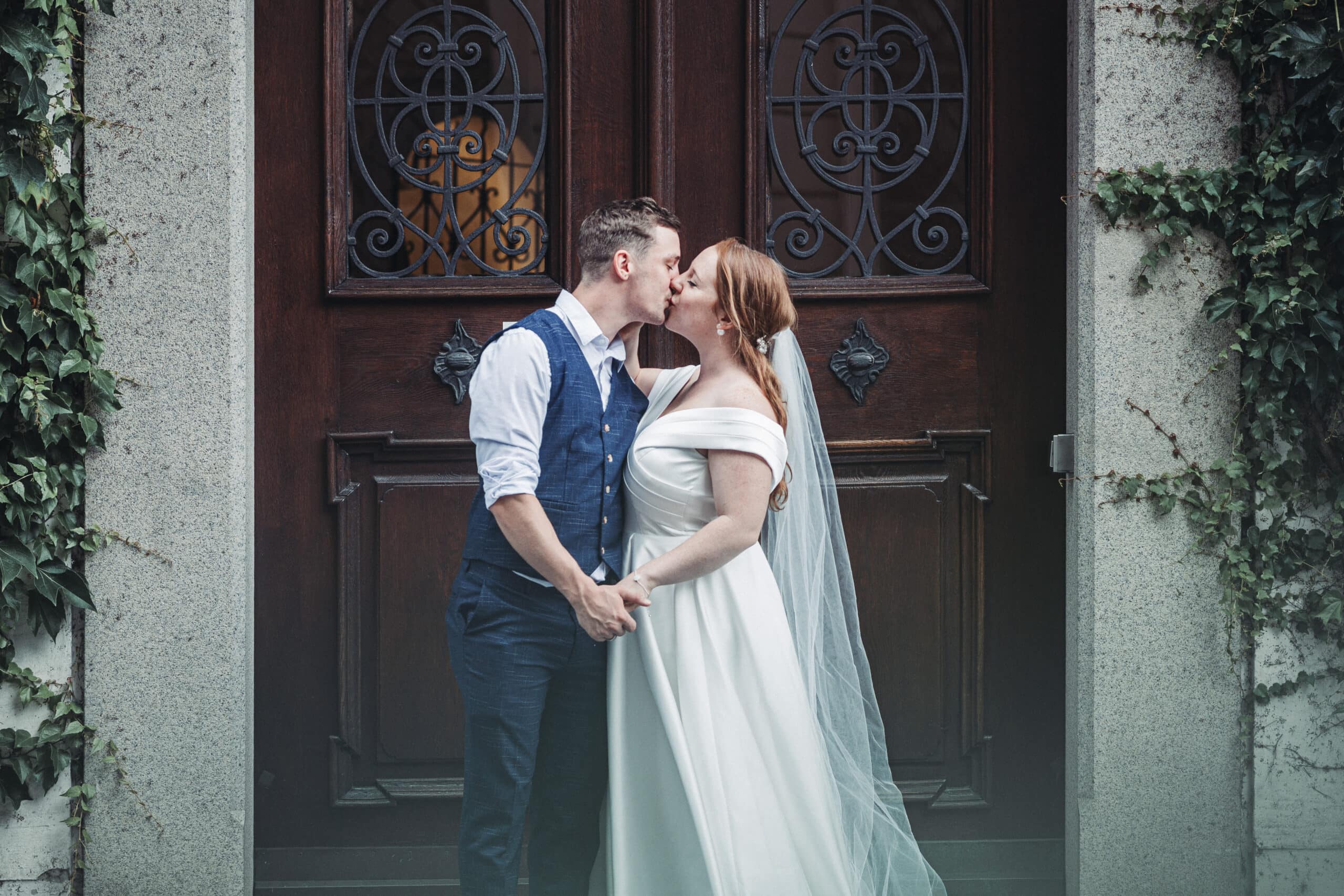 Das Brautpaar küsst sich vor dem Standesamt in Augsburg in der Altstadt.
