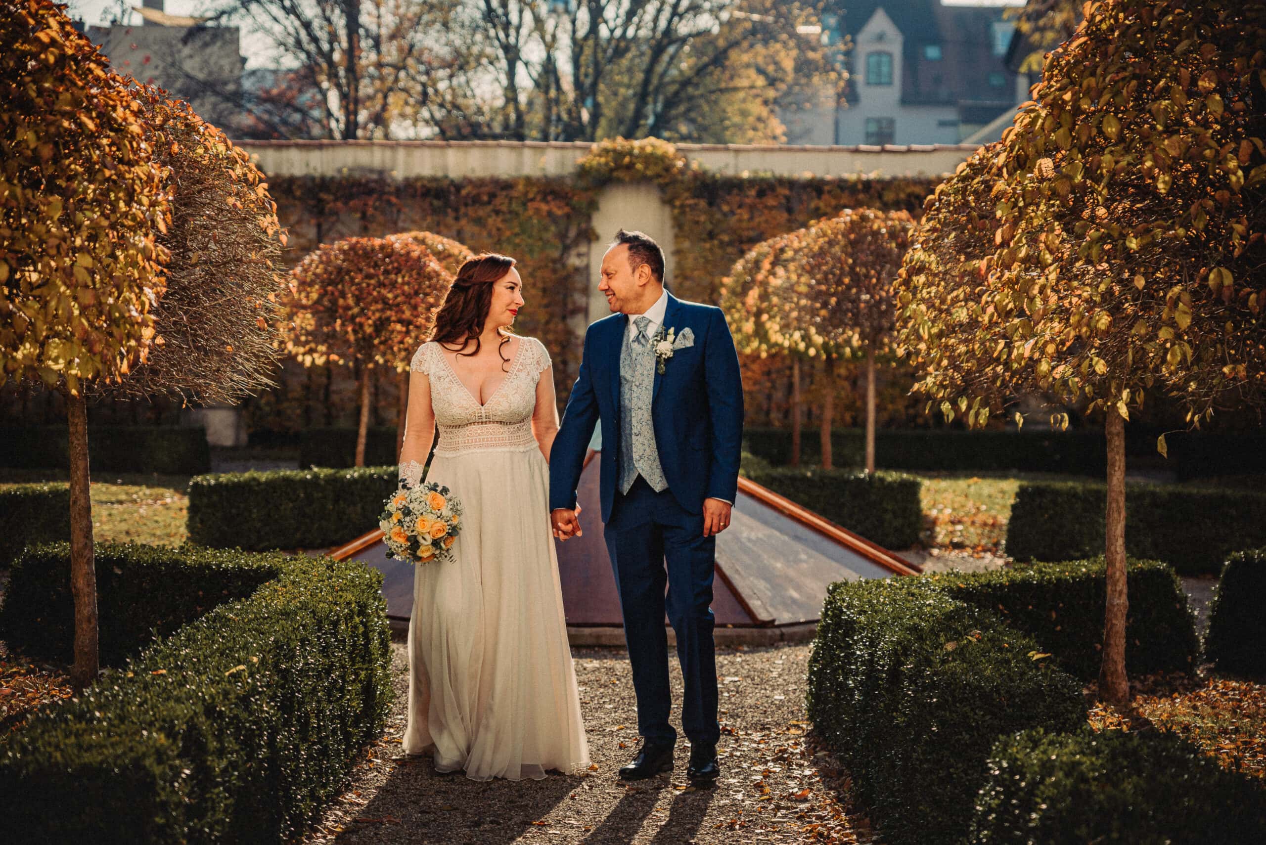 Das Brautpaar ist glücklich und spaziert Hand in Hand bei der standesamtlichen Hochzeit in Augsburg beim Fotoshooting im Schaezlerpalais