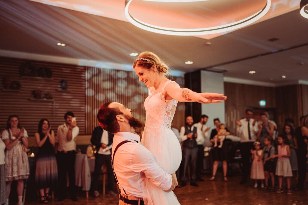 Das Bild ist vom Hochzeitsfotografen bearbeitet. Bei dem Hochzeitstanz hebt der Bräutigam die Braut hoch.