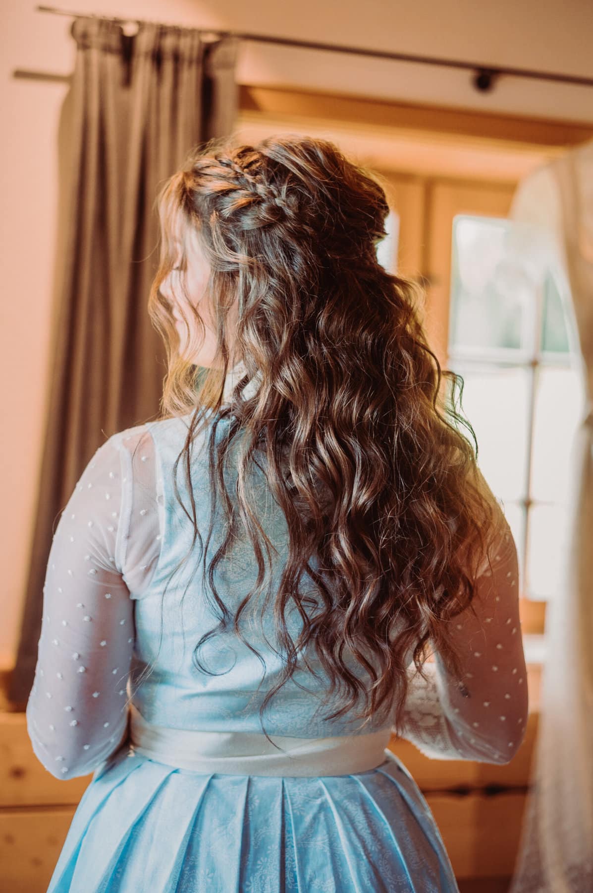 Das Getting Ready der Braut auf der Meckatzer Sportalp. Aufnahme der Braut von hinten mit den fertig gestylten Haaren.