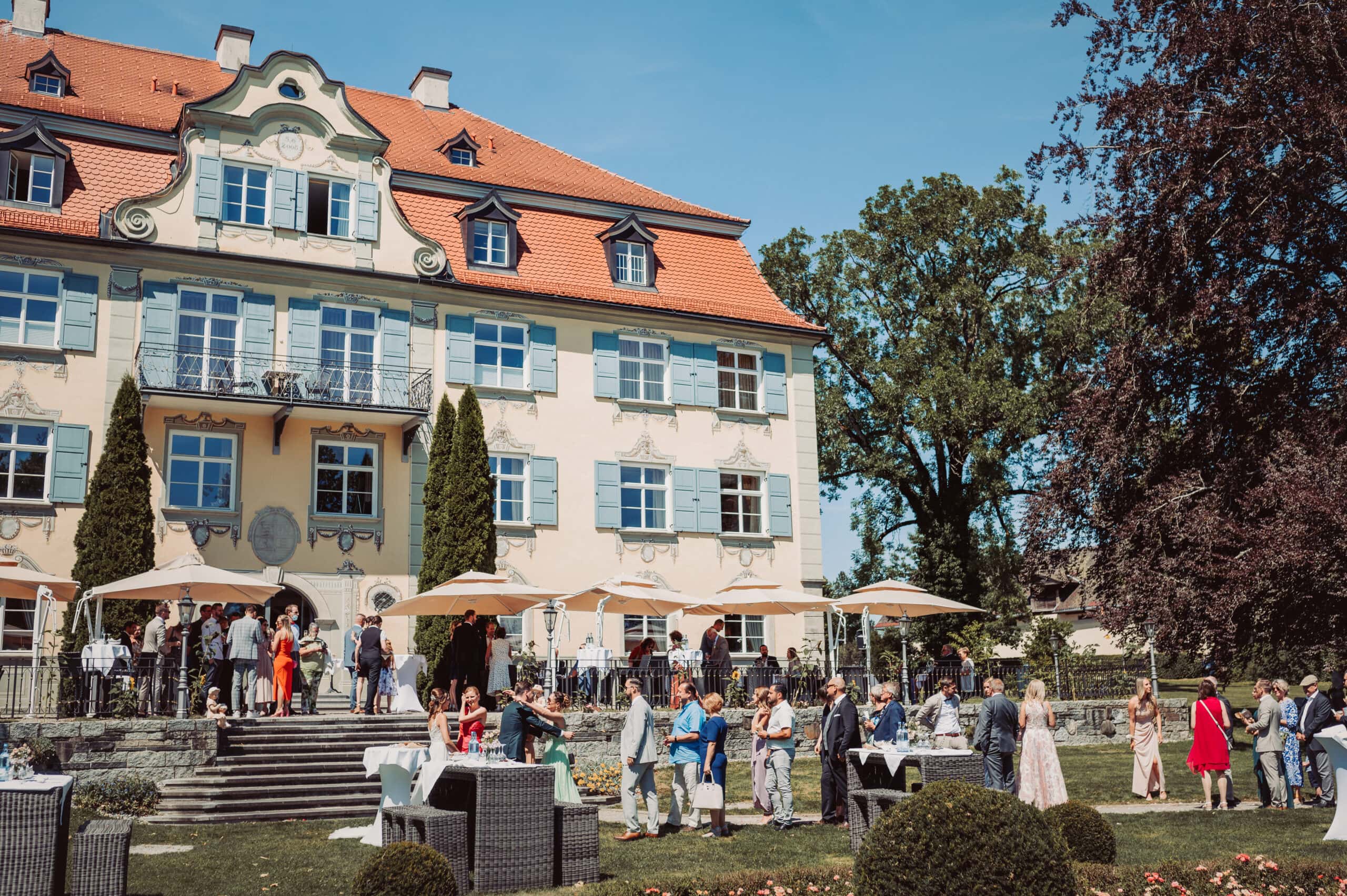 Die Trauung in Isny im Allgäu auf Schloss Neutrauchburg. Die Gäste gratulieren dem Brautpaar vor dem Schloss Neutrauchburg.