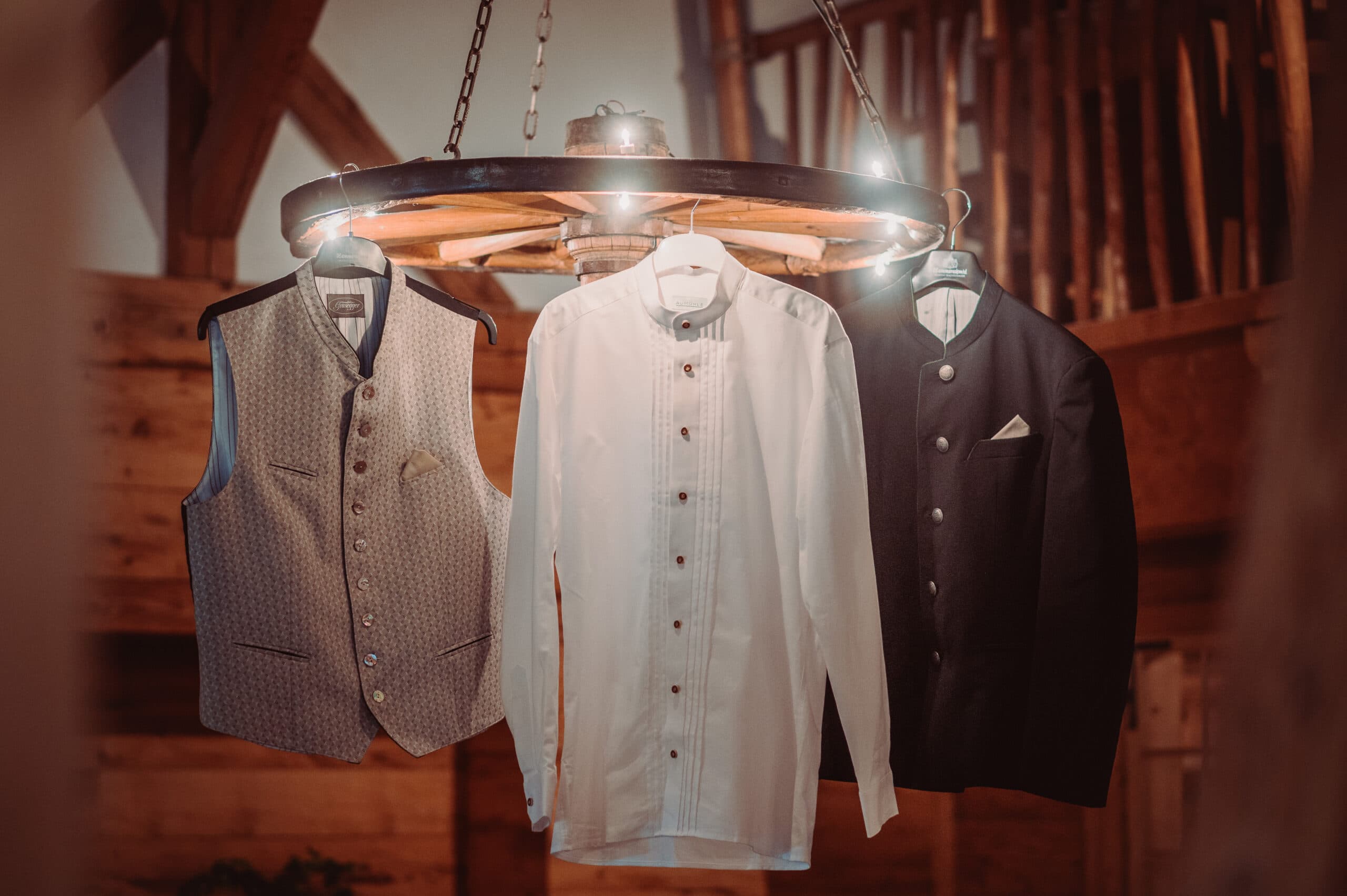 Das Getting Ready vom Bräutigam auf der Meckatzer Sportalp. In einem Raum aus Holz hängt die Weste, das Hemd und die Jacke vom Bräutigam