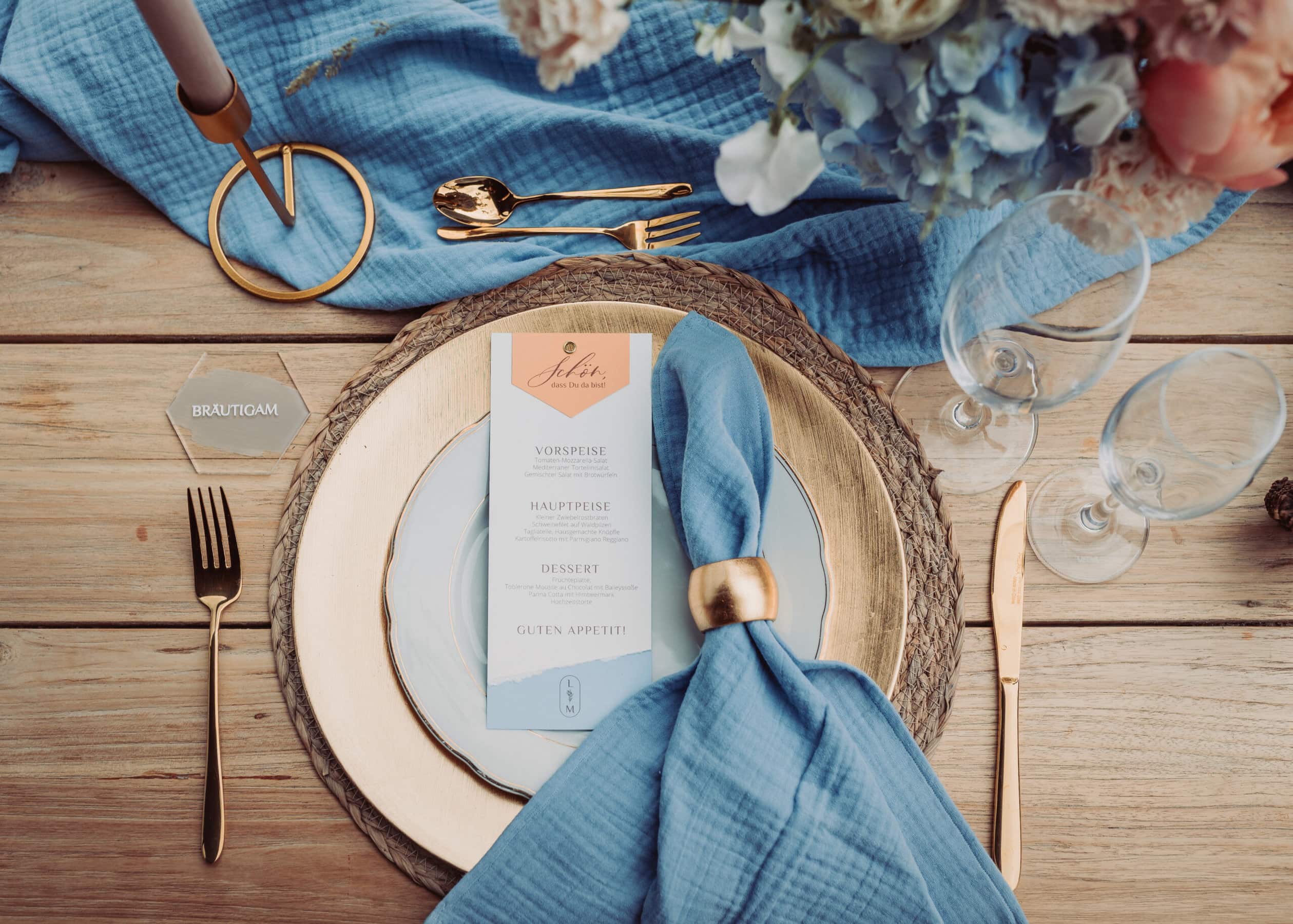 Das Tischgedeck der Hochzeit auf der Meckatzer Sportalp. Eine Nahaufnahme des gedeckten Tisches mit dem Teller und der Speißekarte zusehen.