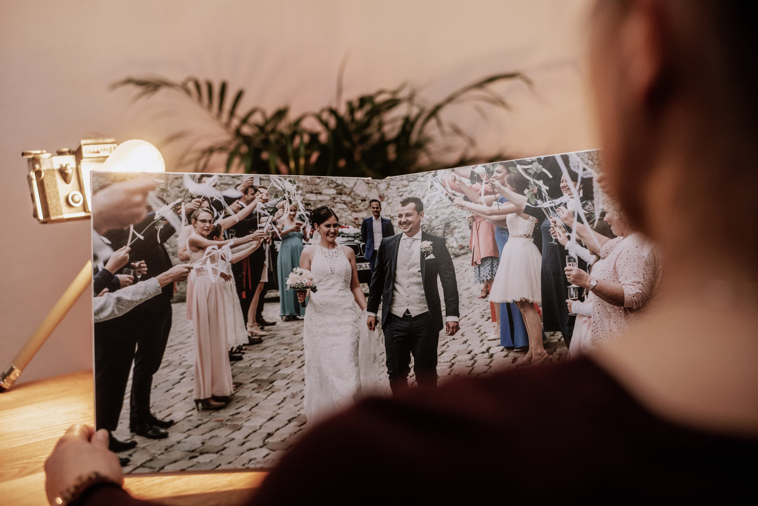 Die Braut hält ihr Fotobuch in den Händen und betrachtet es.