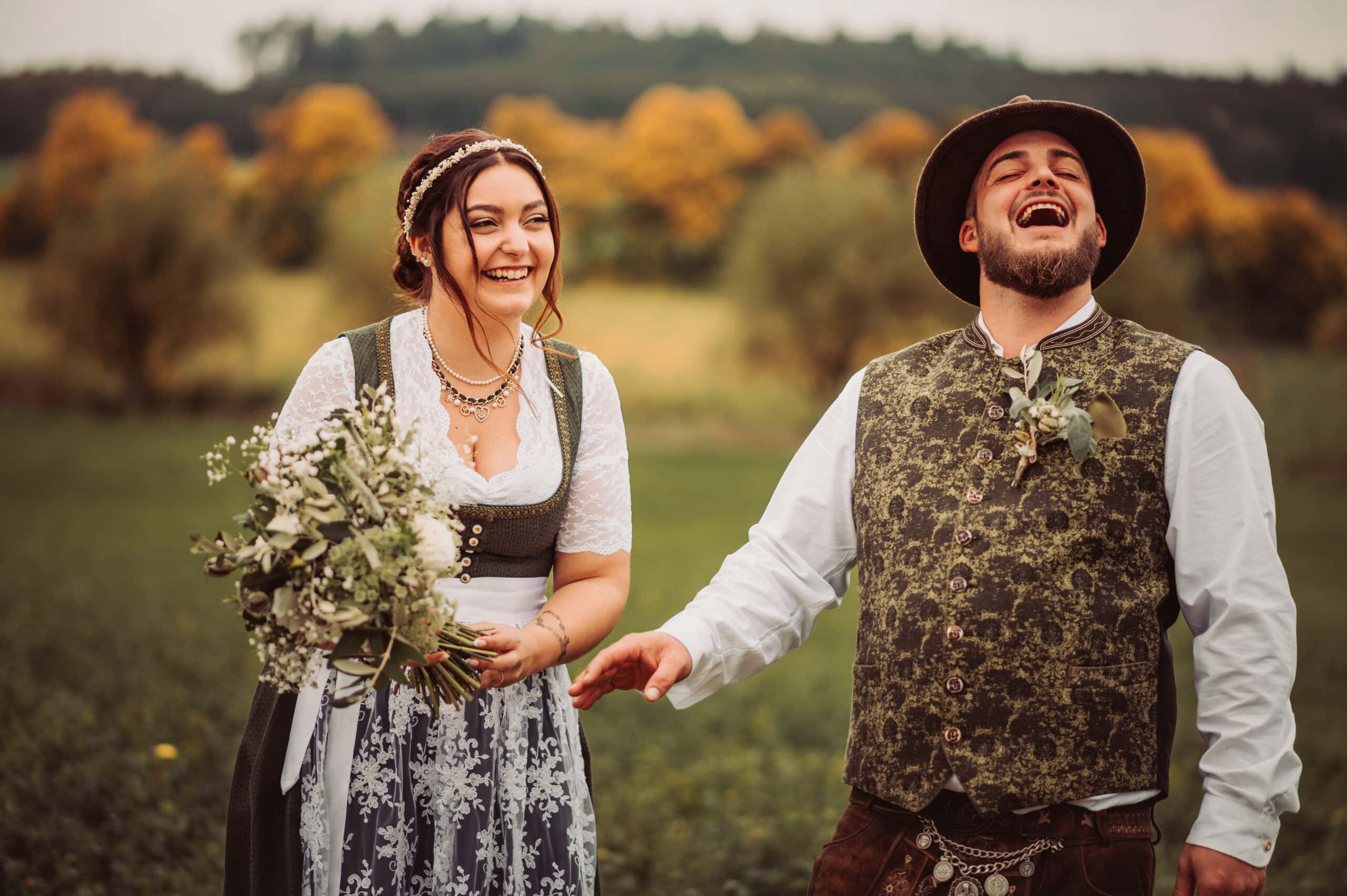 Das lachende Brautpaar beim Brautpaarshooting auf einem Feld in Pöttmes.