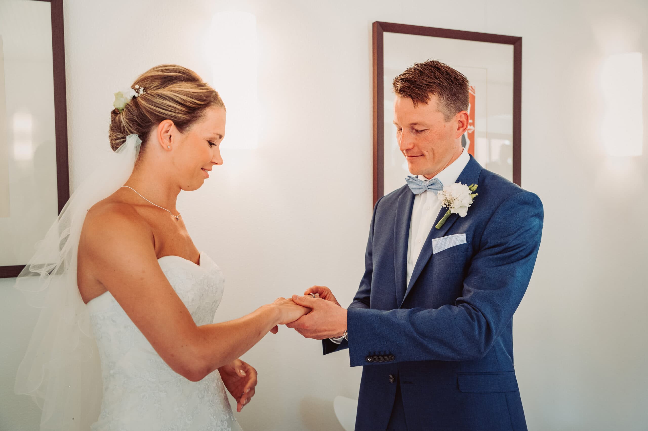 Der Bräutigam steckt der Braut den Ehering bei der Hochzeitsfeier im Standesamt in Pöcking an.