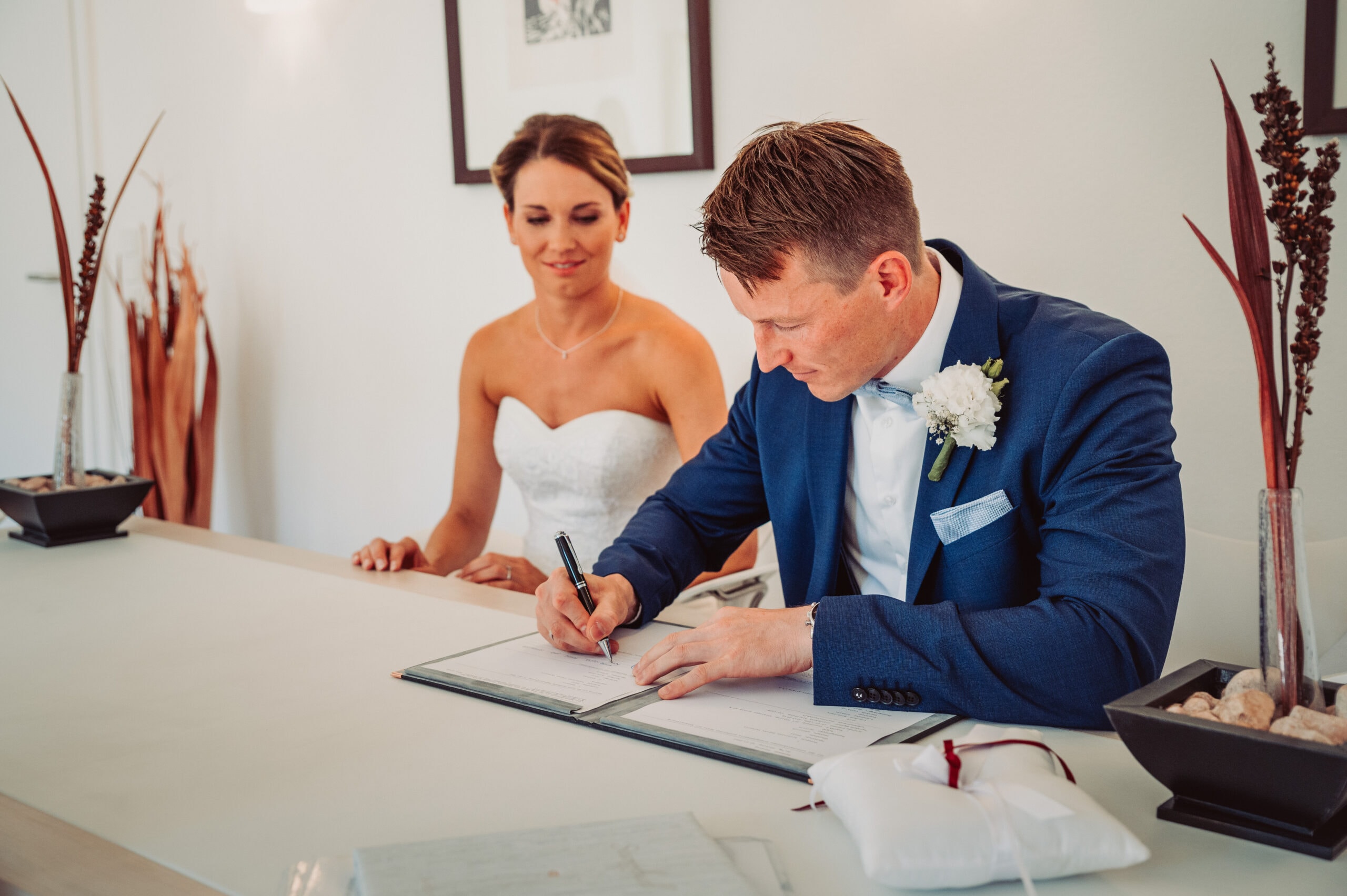 Der Bräutigam unterschreibt die Heiratsurkunde im Standesamt in Pöking.