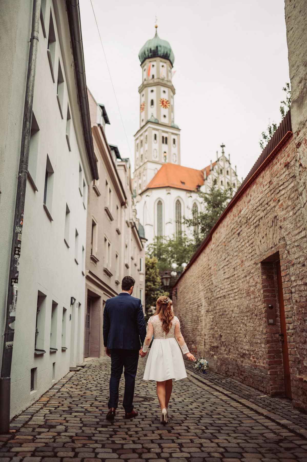 Brautpaar spaziert in Augsburger Gasse mit Blick auf St. Ulrich