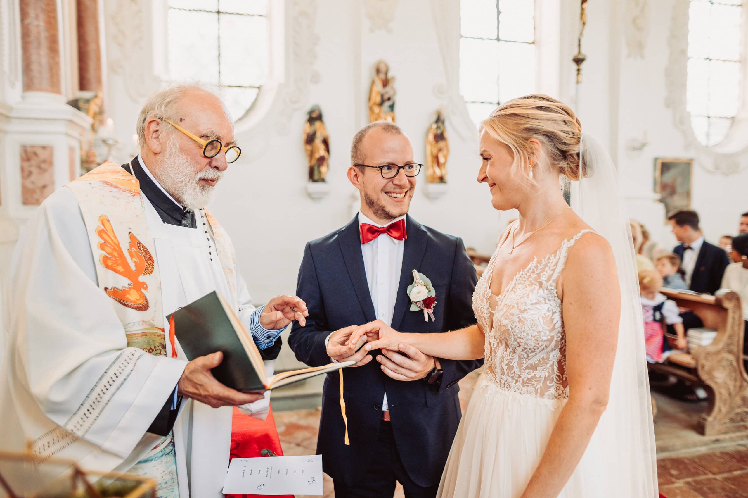 Brautpaar vor dem Altar beim Anstecken der Ringe